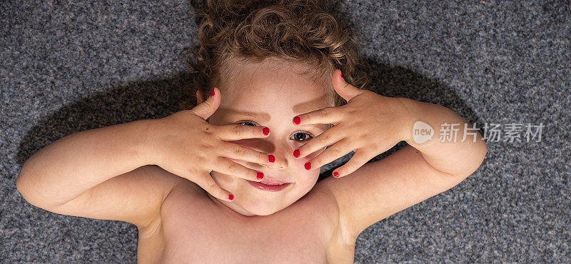 一个五岁白人女孩的肖像。孩子从指缝间的眼神。特写镜头。