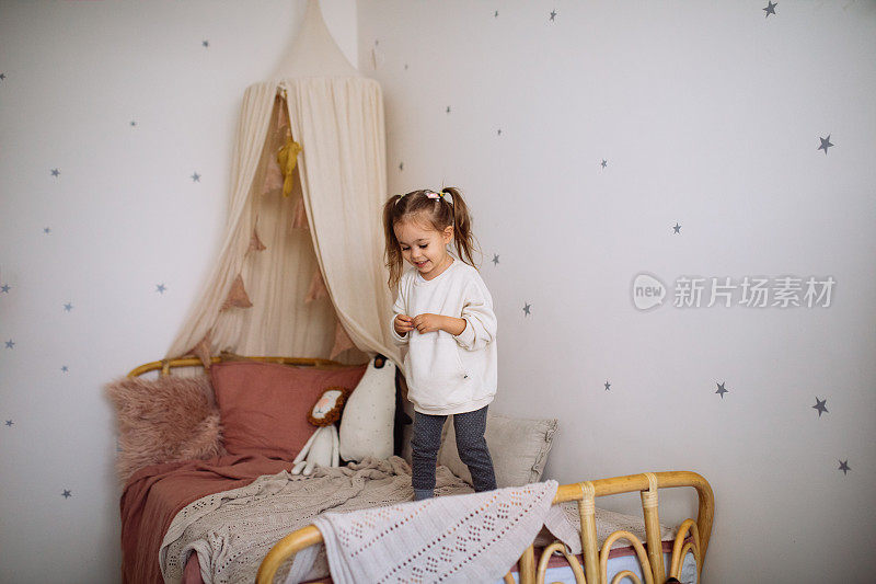 快乐的小女孩蹦蹦跳跳玩床