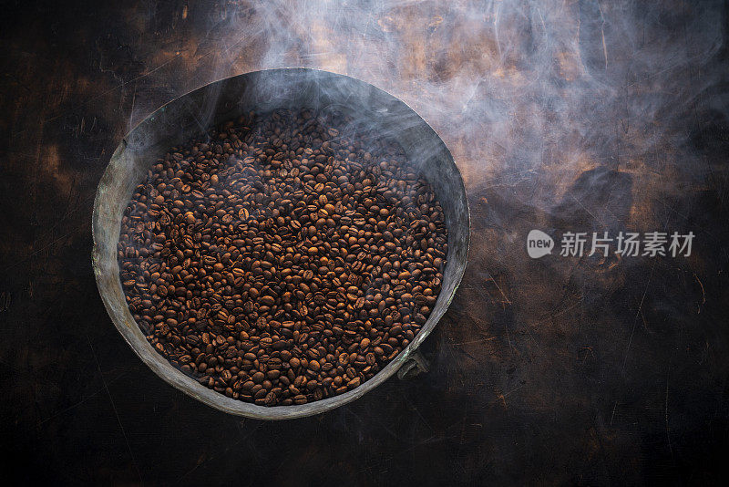 中度烘焙的咖啡豆在木头上的烤盘里有烟熏的味道