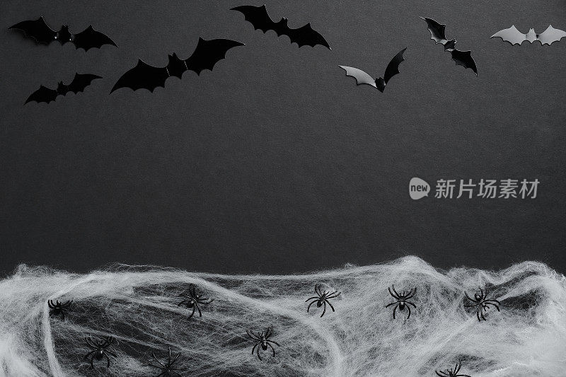 万圣节平铺构图由蝙蝠的轮廓和蜘蛛网在黑色的背景。万圣节节日快乐概念