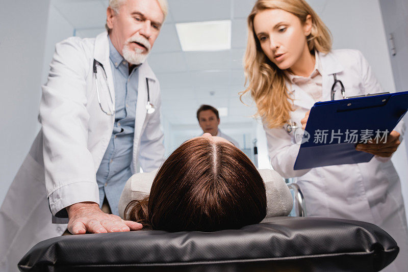 门诊病人在带写字板的医生旁边的担架上选择性聚焦