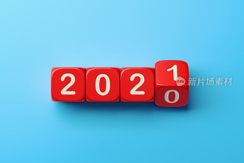 蓝色背景下的红色骰子从2020年滚动到2021年