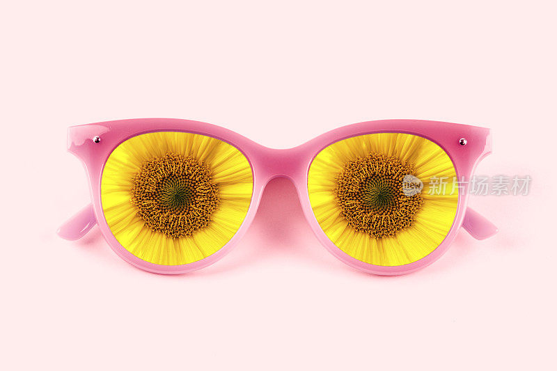 粉红色的太阳镜在粉红色的背景和向日葵
