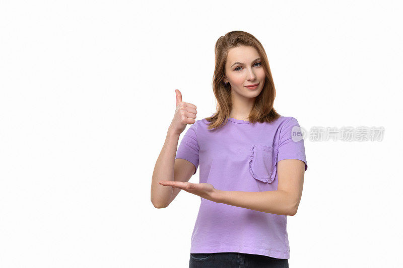 美丽的年轻女子穿着休闲t恤显示拇指向上的手势和微笑