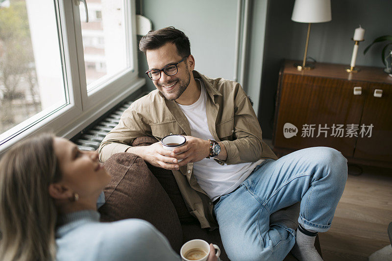 高角度的一个幸福的年轻白种人夫妇享受一杯咖啡在家里