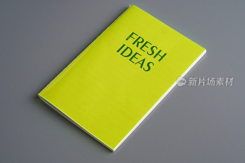黄色笔记垫与文本新鲜的想法在灰色的背景