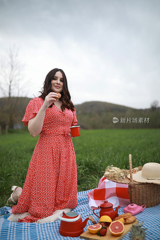 美丽的女人在大自然中喝茶和野餐，共度美好的户外时光