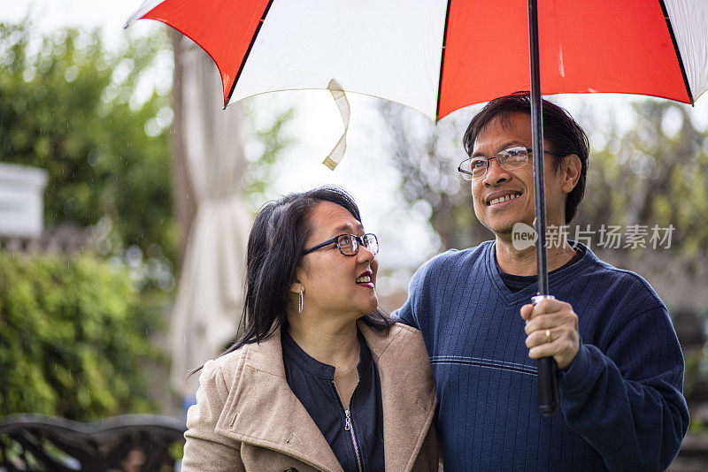 雨中撑伞的亚洲情侣