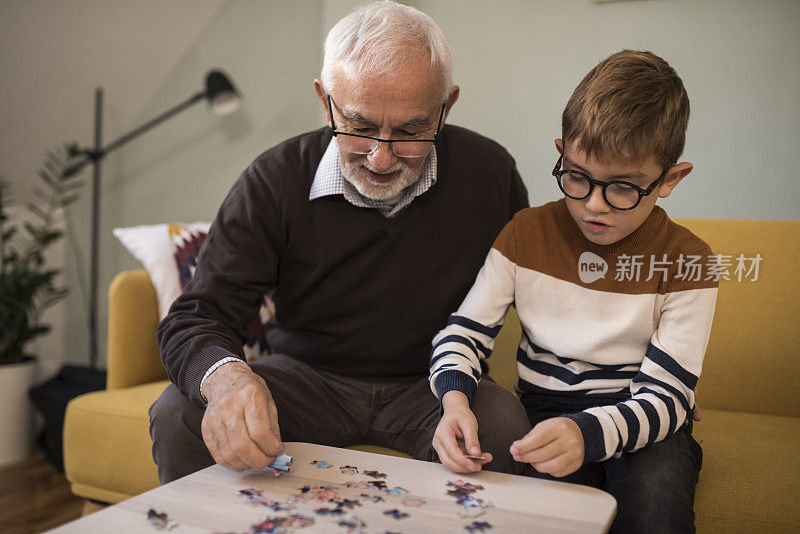 男孩和他的爷爷在叠拼图