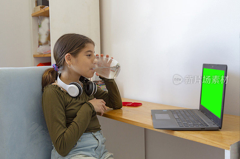 一个女孩看着听着她的笔记本电脑