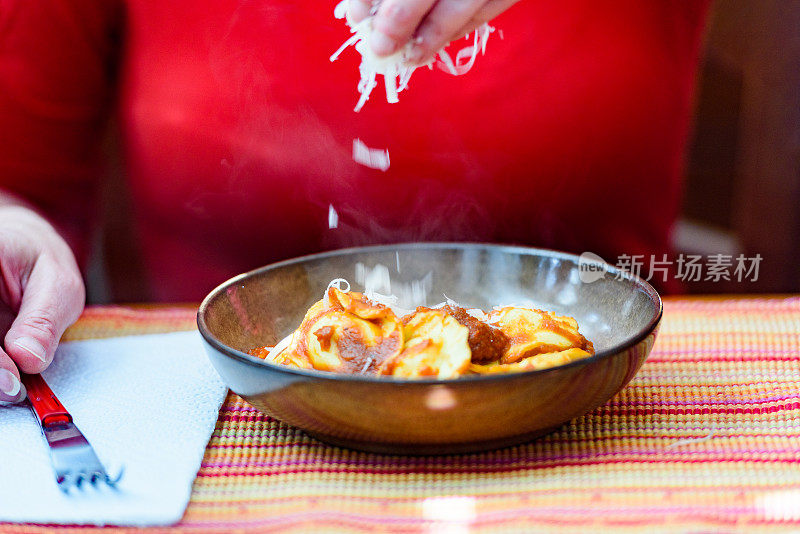 近距离拍摄吃意大利传统食物——番茄酱饺子的女人