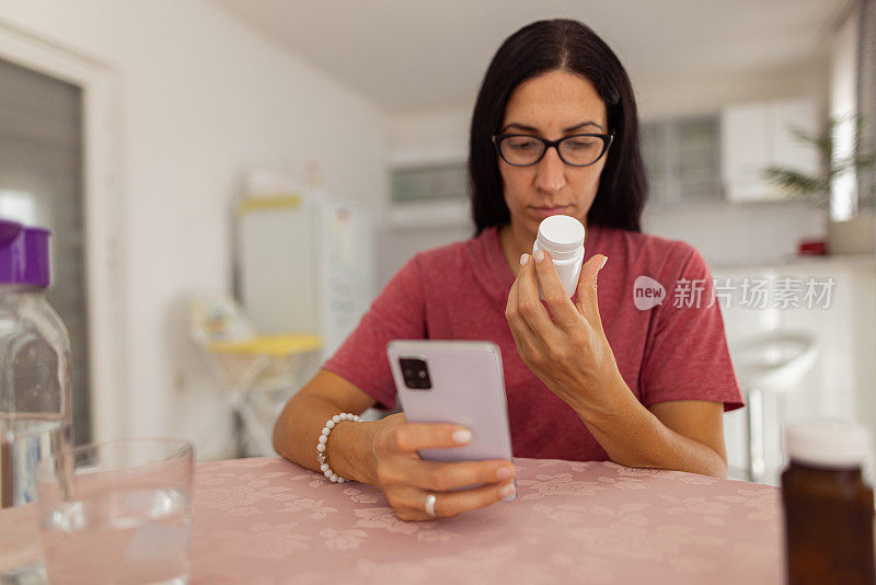 一个年轻的女人正在看药瓶上的标签