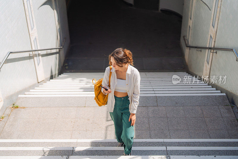 一名女子在走出地铁时使用智能手机