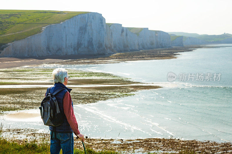 一位资深的徒步旅行者在看英格兰南部七姐妹悬崖和大海的景色