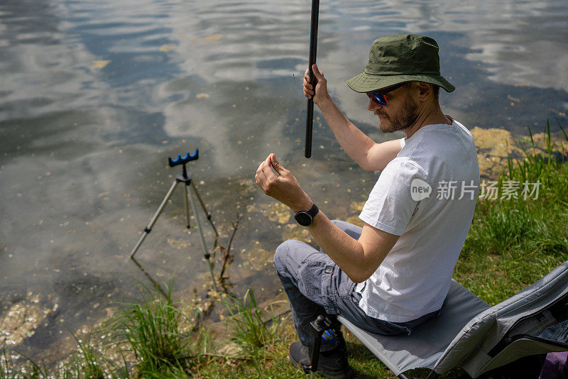 在浮子钓鱼时，渔夫正在检查鱼饵。