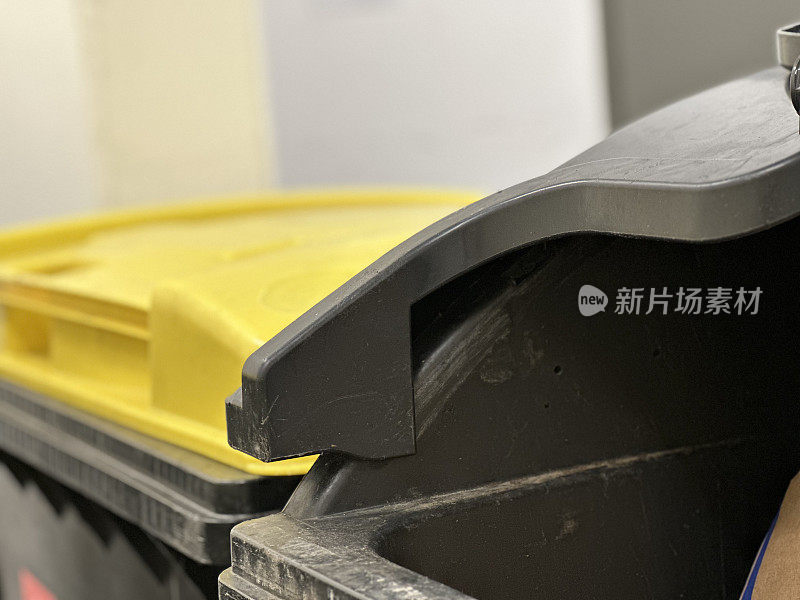 黄色和黑色的回收箱，用于德国公寓垃圾室的塑料和残余废物