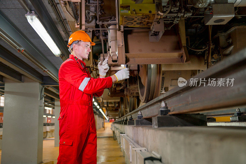 专业技术人员在电气或地铁车辆厂拿着灯管检查和维修部分列车。