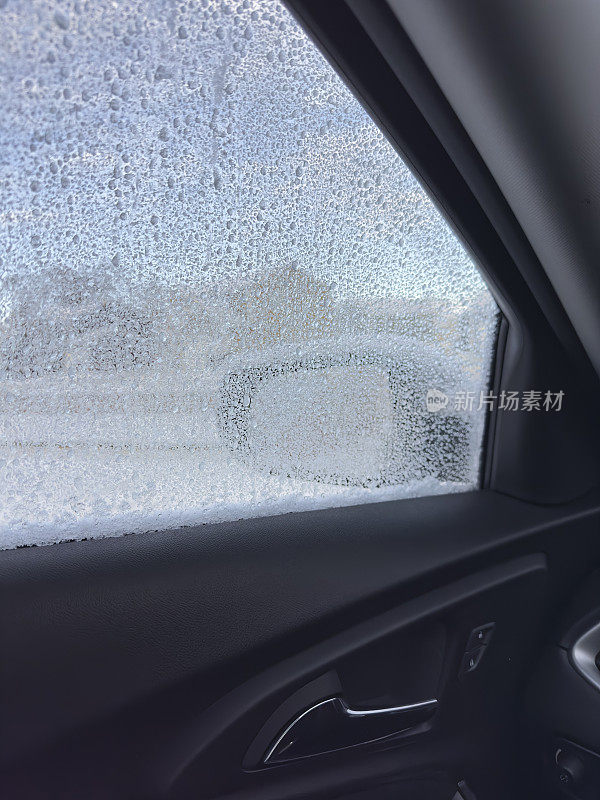 从覆盖着冰雪的汽车驾驶座窗户里看到的景象