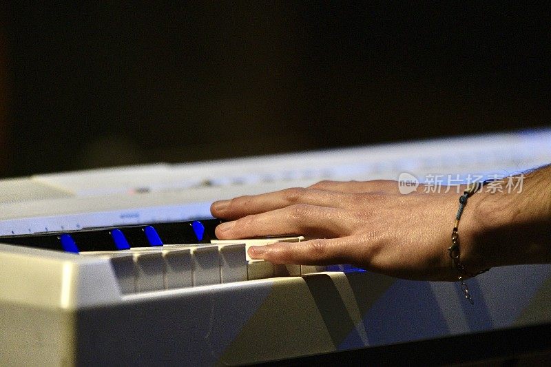 手放在键盘上，音乐家在舞台上弹钢琴