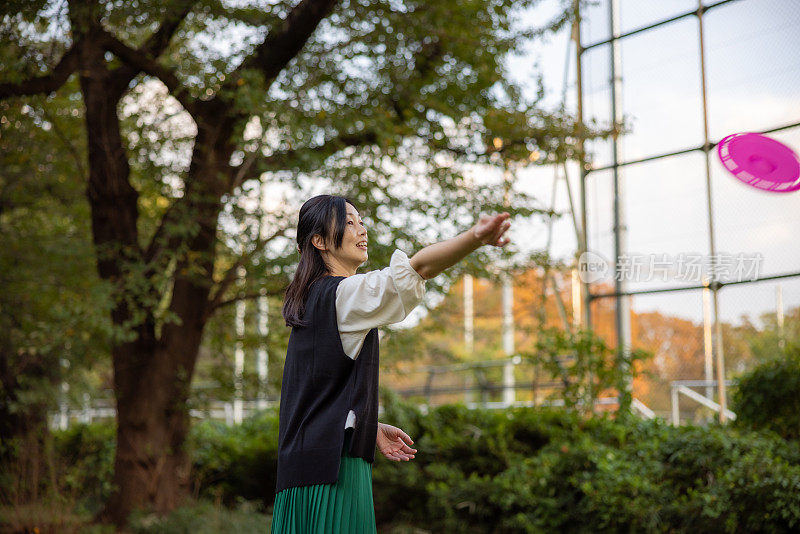 一名女子在公园投掷飞盘