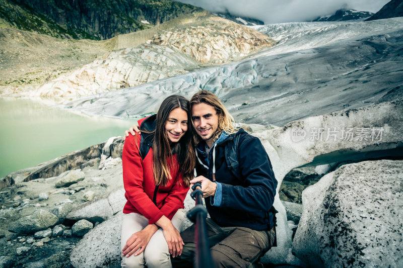 一对年轻夫妇在瑞士阿尔卑斯山徒步旅行，自拍