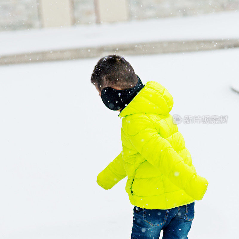 一个亚洲男孩在雪地里玩