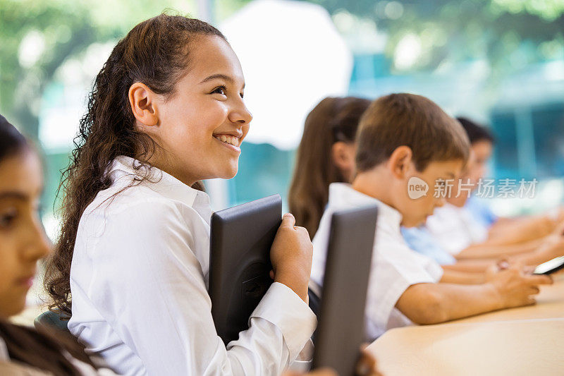 十来岁的学生在私立学校教室里使用数字平板设备