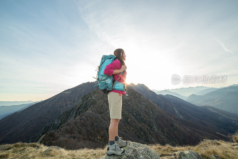 年轻女子徒步到达山顶，看风景