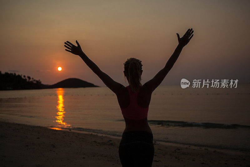 日落时海滩上女人的剪影