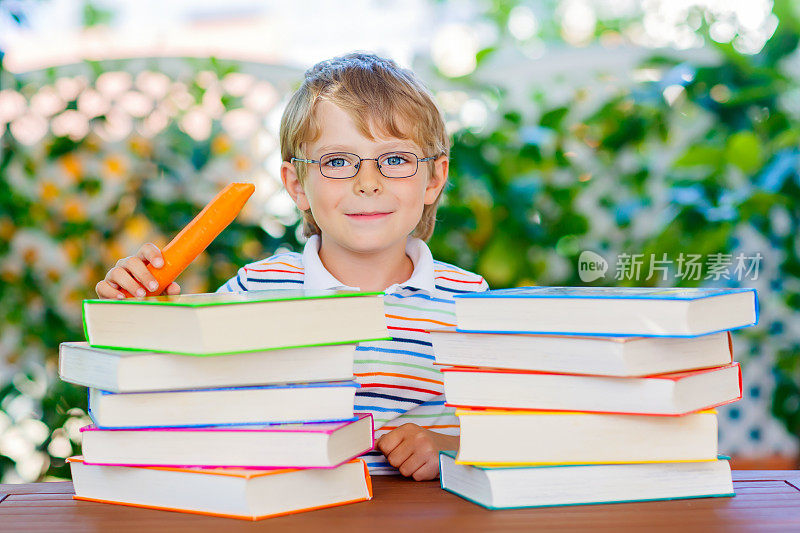 带着眼镜和书的快乐小男孩