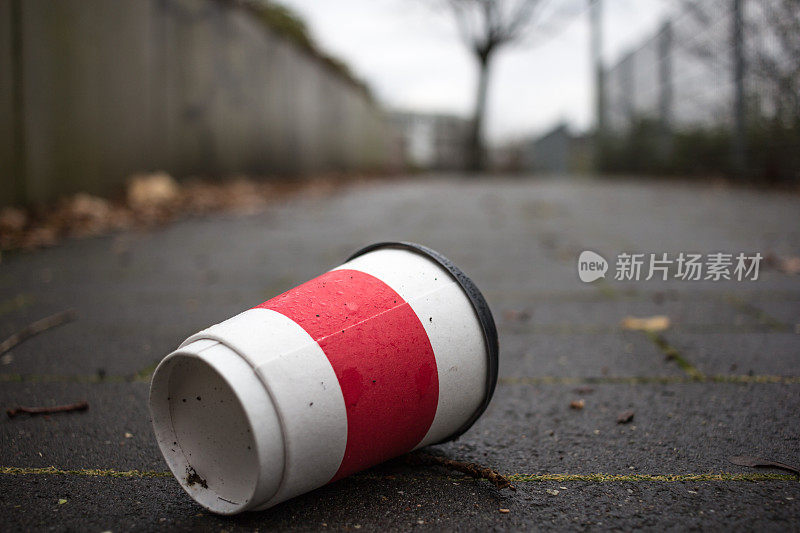 用过的咖啡杯放在人行道上作为污染的象征。