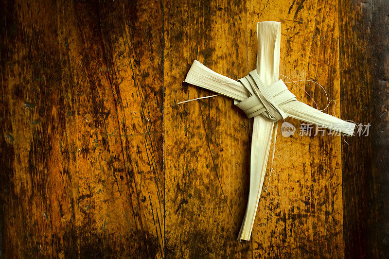 木制长凳上棕榈枝做成的复活节十字架