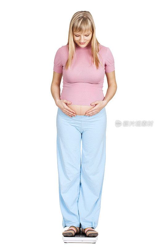 一名年轻孕妇正在用秤量体重