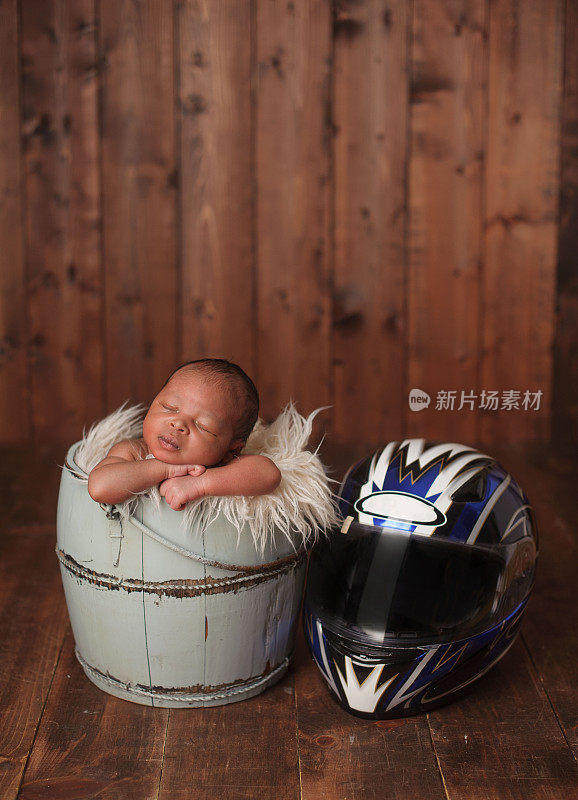新生儿在摩托车头盔旁睡觉