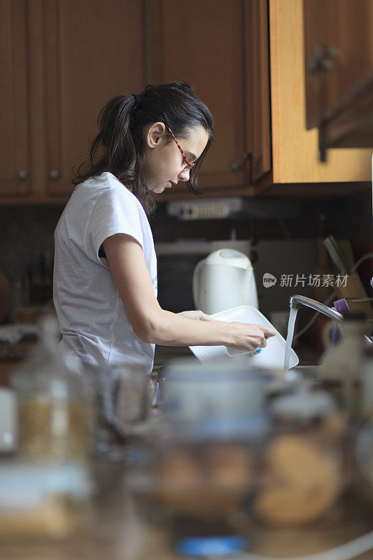 心力交瘁的少女用手洗盘子和盘子