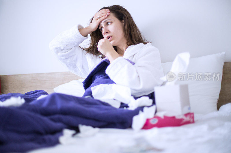 生病的女人患流感头痛在床上