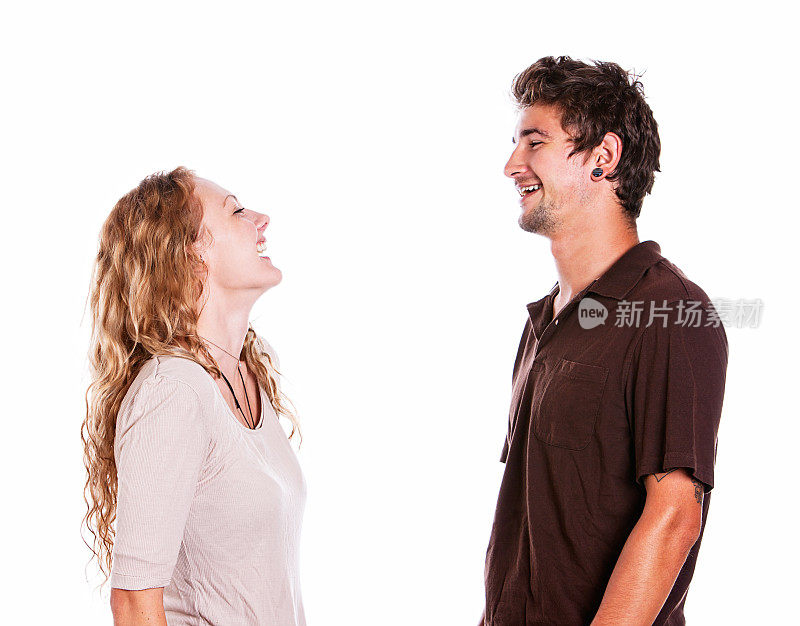 幸福的年轻夫妇面对彼此大笑