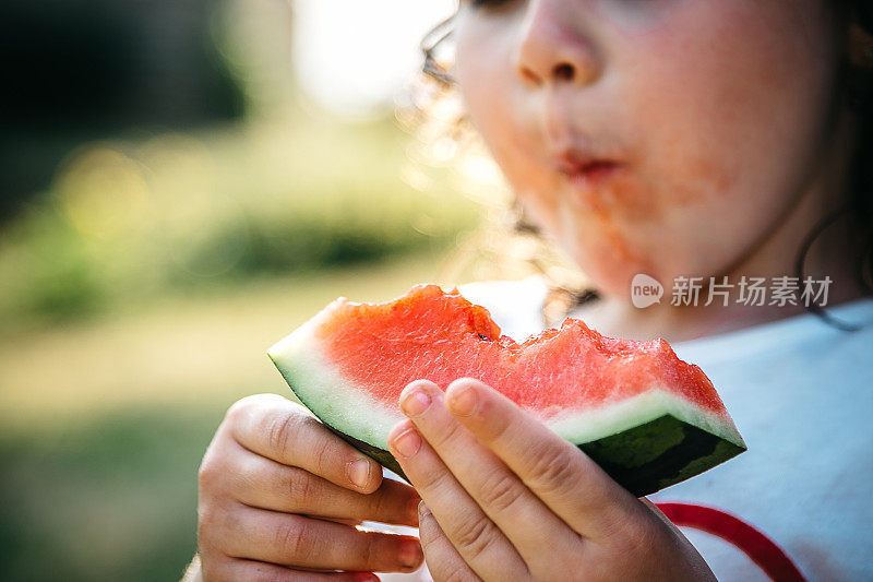 可爱的小女孩吃着西瓜