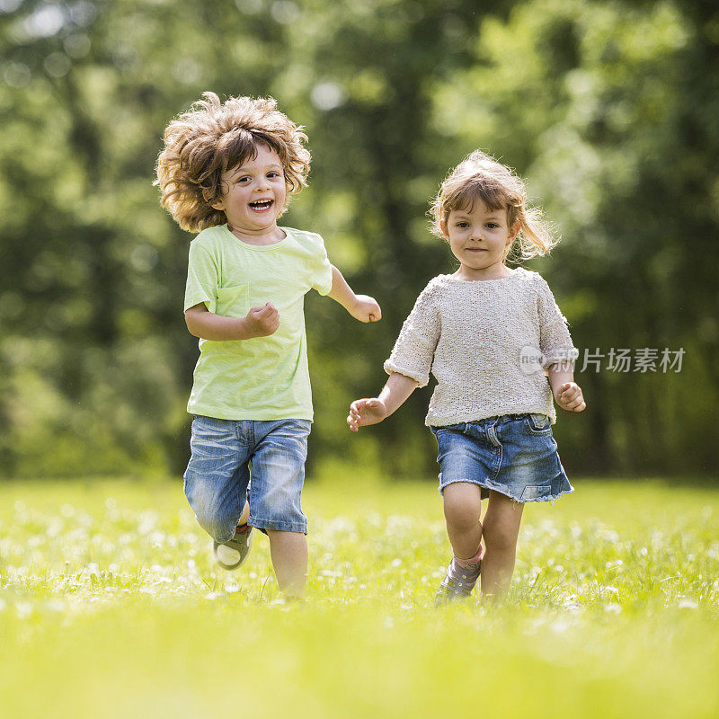 快乐的小男孩和小女孩在大自然中奔跑。