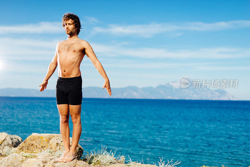 夏天在海滩悬崖上练习瑜伽和冥想