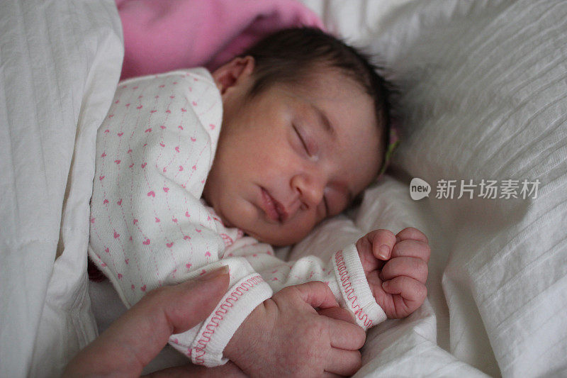 熟睡的新生儿握着妈妈的手指