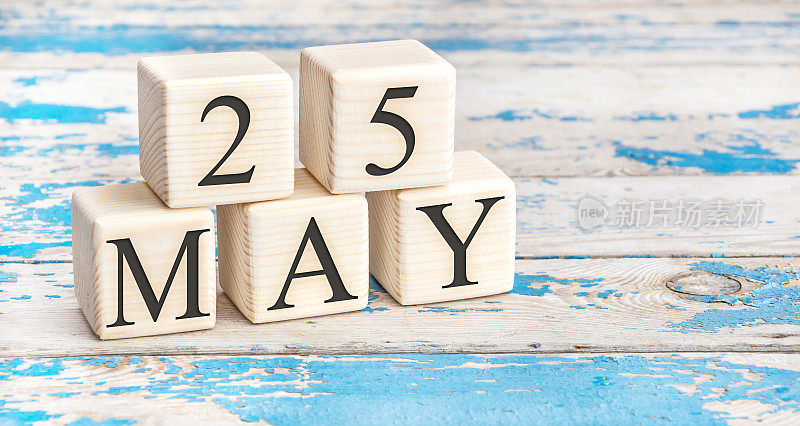 5月25日。木制立方体与日期5月25日在旧的蓝色木制背景。