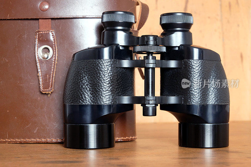 老式棱镜黑色双筒望远镜和棕色皮箱