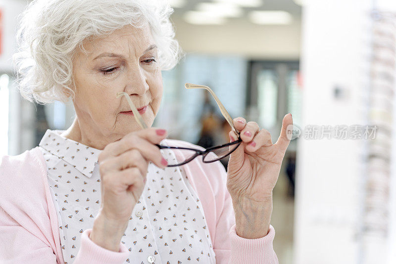 有兴趣的老妇人选择眼镜