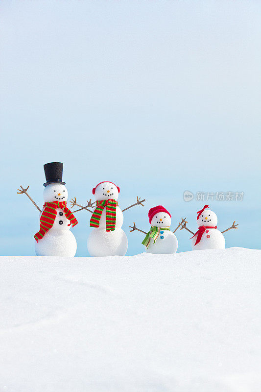 雪人家庭与孩子肖像在雪与天空的背景