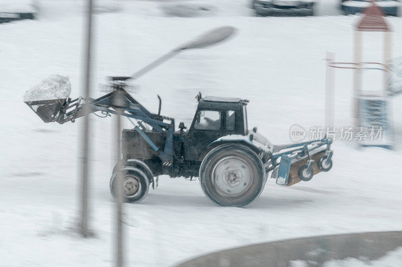 拖拉机清理操场上的积雪