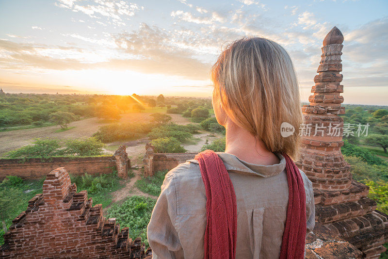 白种人年轻女子凝视蒲甘考古区在日出，缅甸