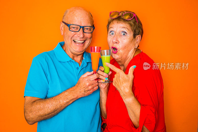 色彩激增时尚老年人，幸福夫妇与橙汁
