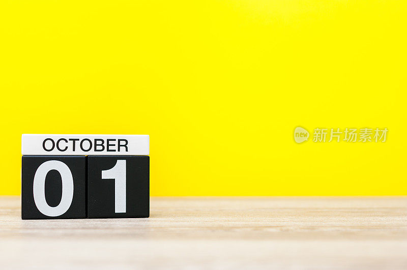 10月1日。月1日，黄色底色木制日历。秋天的时间。文本空白