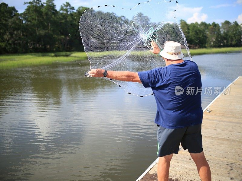 渔民抛出大型捕虾渔网码头